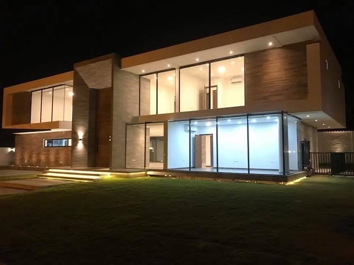Residencia moderna de dos plantas construida por DALVCO, iluminada de noche